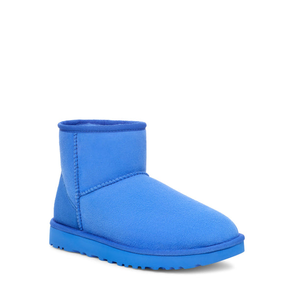 Blue ankle-height boot with a rounded toe and a flat sole on a white background.