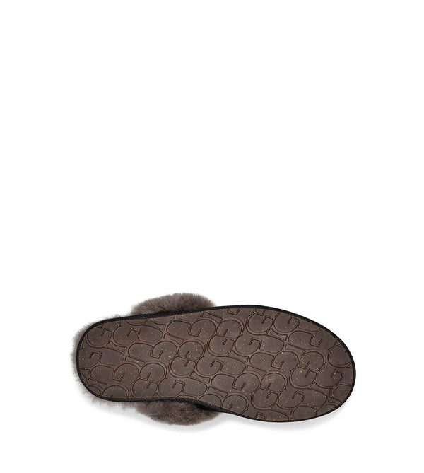 bottom view of a single black UGG slipper with fluffy lining on a white background.