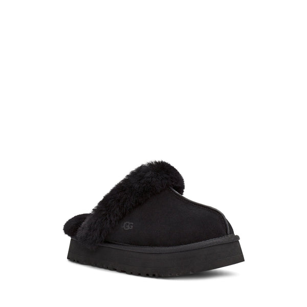 Black fluffy slipper with brand logo on a white background.