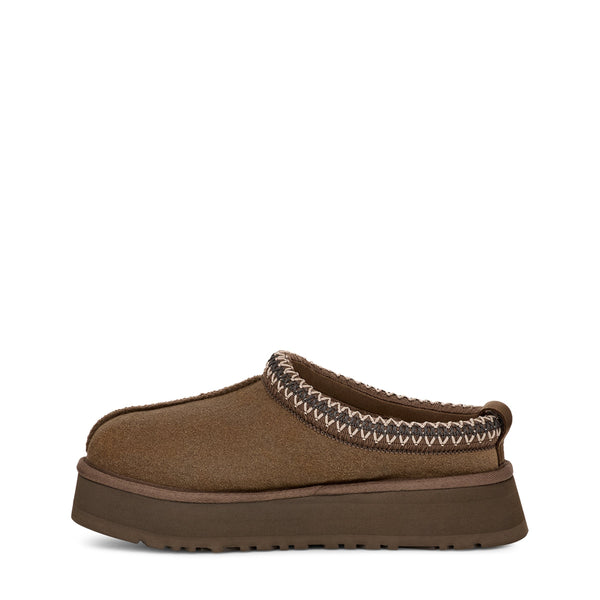 Brown slip-on shoe with decorative stitching and thick sole, isolated on white background.