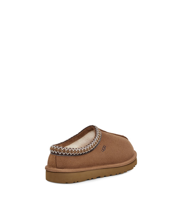 Back view of a single tan slip-on shoe with decorative stitching on a white background.