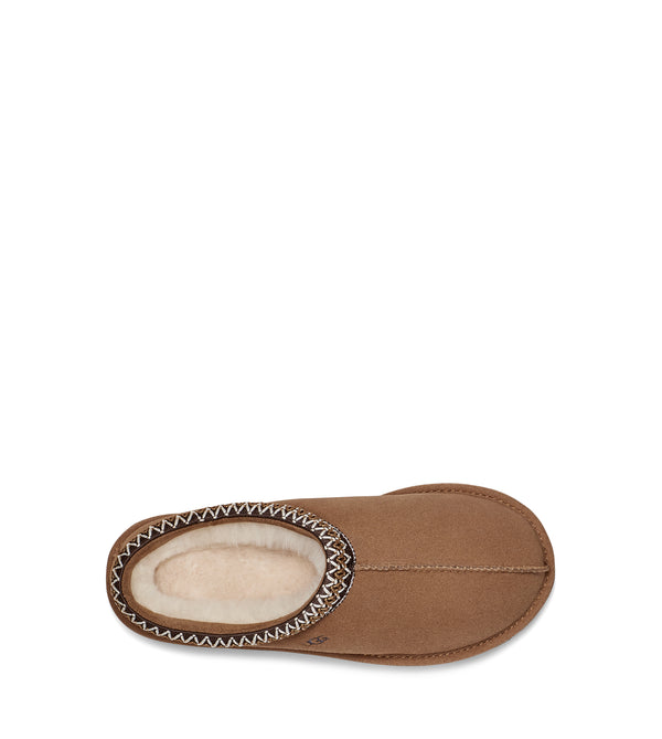 Top view of a single tan slip-on shoe with decorative stitching on a white background.