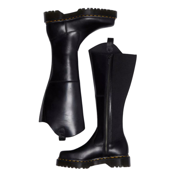 A pair of black knee-high boots with yellow stitching and side zippers on a white background.