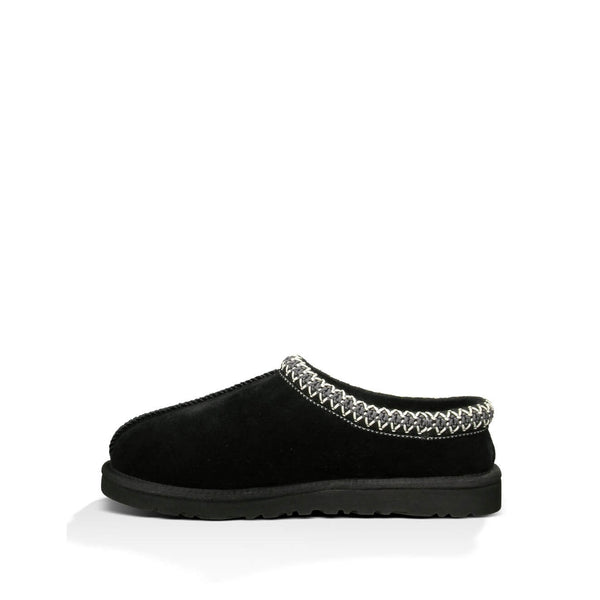 Black UGG slipper with braided trim detail on a white background.